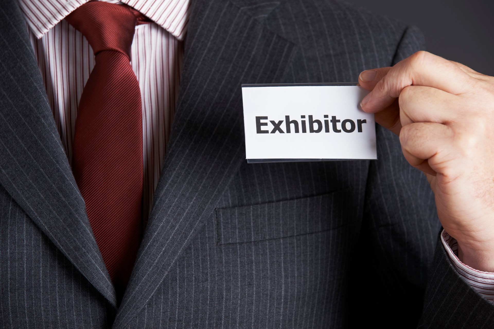 Businessman Attaching Exhibitor Badge To Jacket